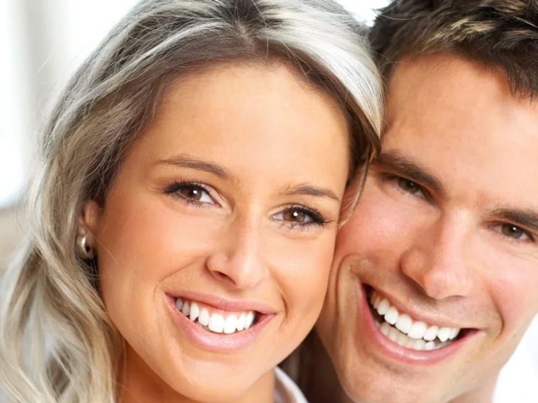 A couple with bright, confident smiles