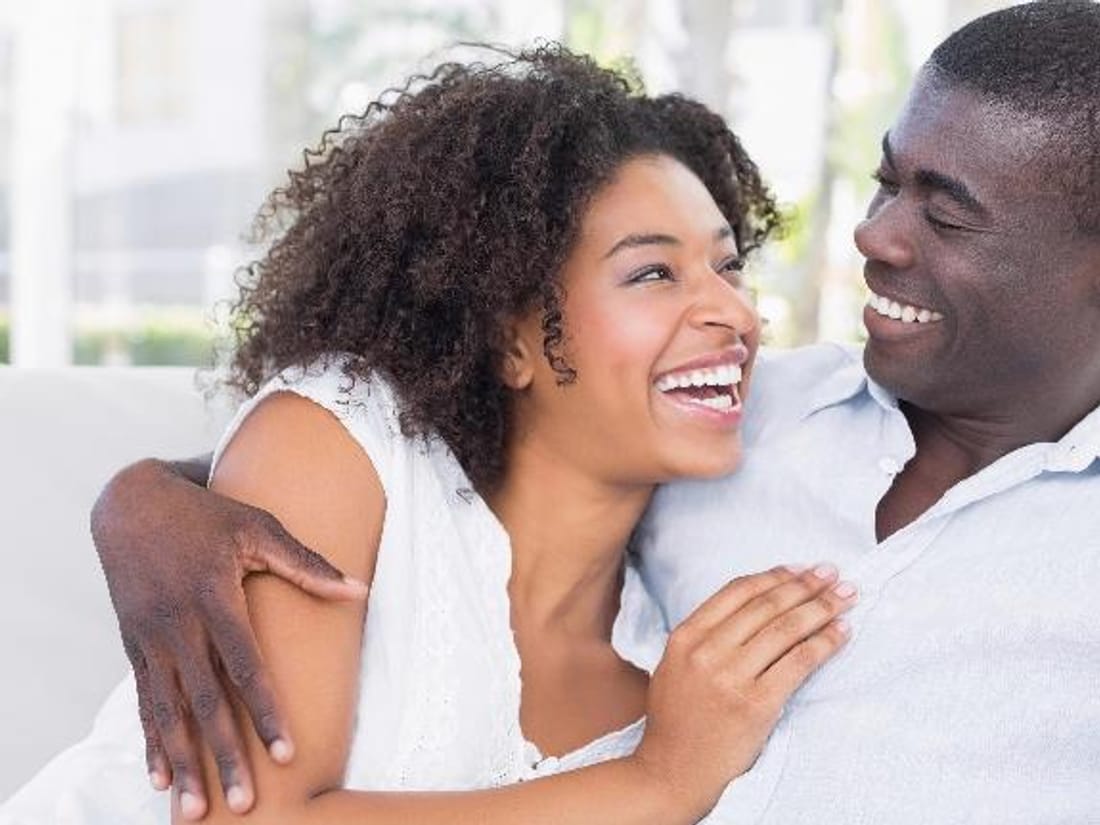A couple laughing together at home