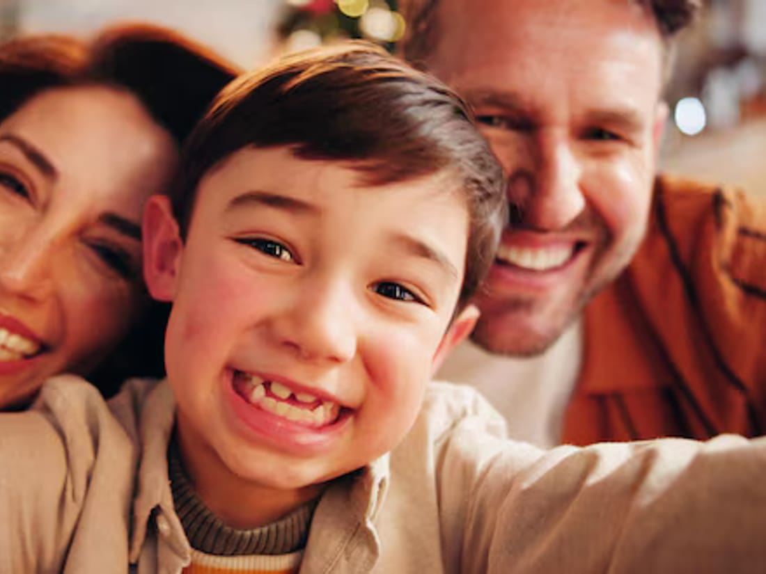 A child grinning with his parents